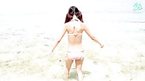 Wading into ocean wearing bikini