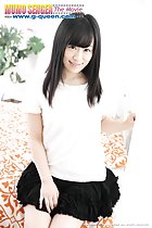 Seated wearing white top and black skirt long hair hand resting between her thighs
