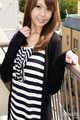 Standing on balcont wearing striped top auburn long hair