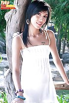 Standing on porch long hair over her shoulder wearing white dress